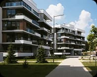 A newly finished residential block with planted balconies, lawns and young trees.